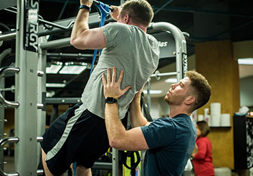 Woman Lifting With Personal Trainer