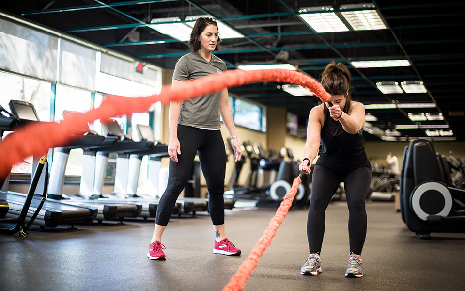 Woman Lifting Weight With Personal Trainer